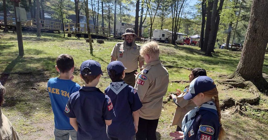 Cub Scouts discuss basic first aid in the field.